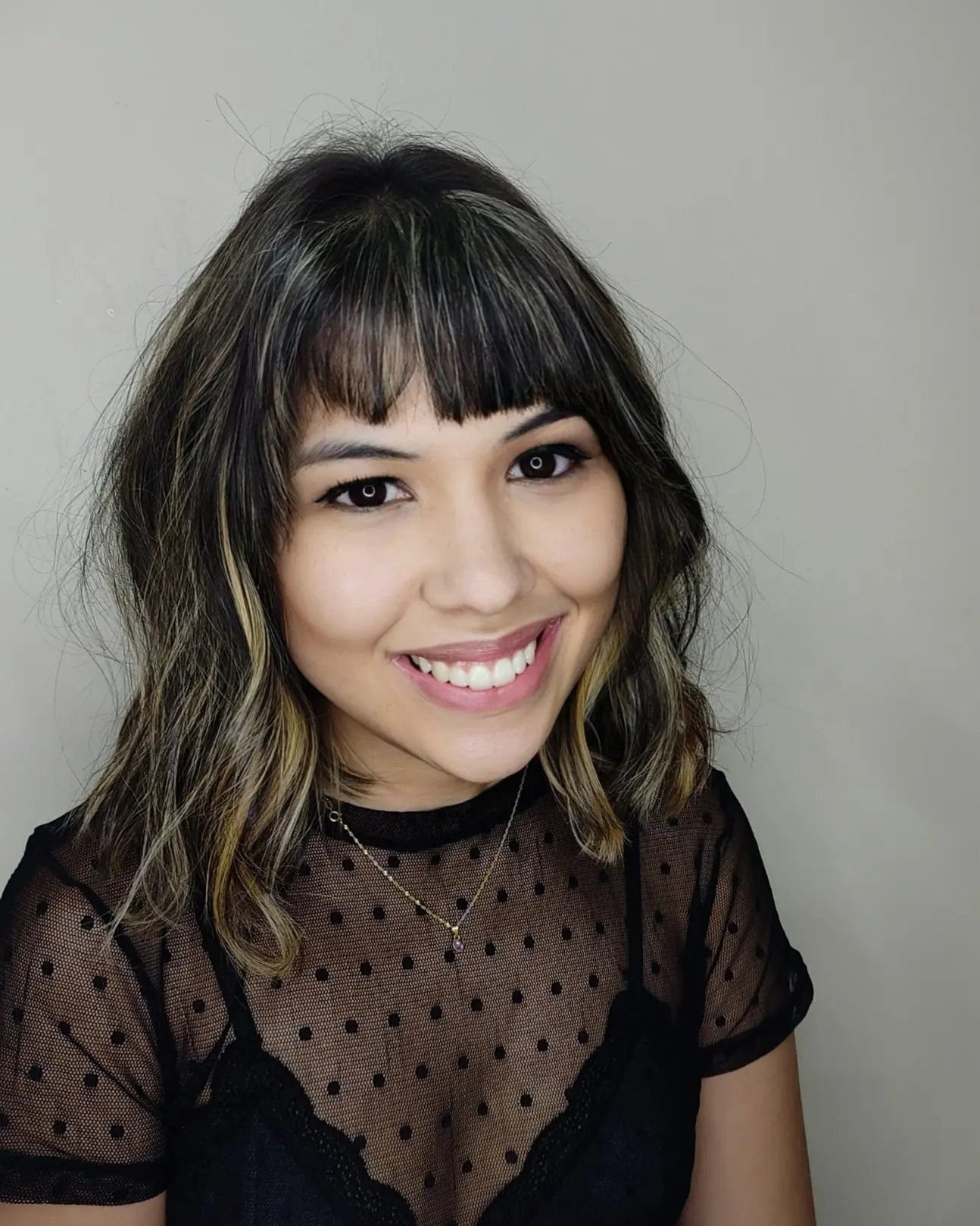 Corte de cabelo feminino médio com franja reta e mechas claras