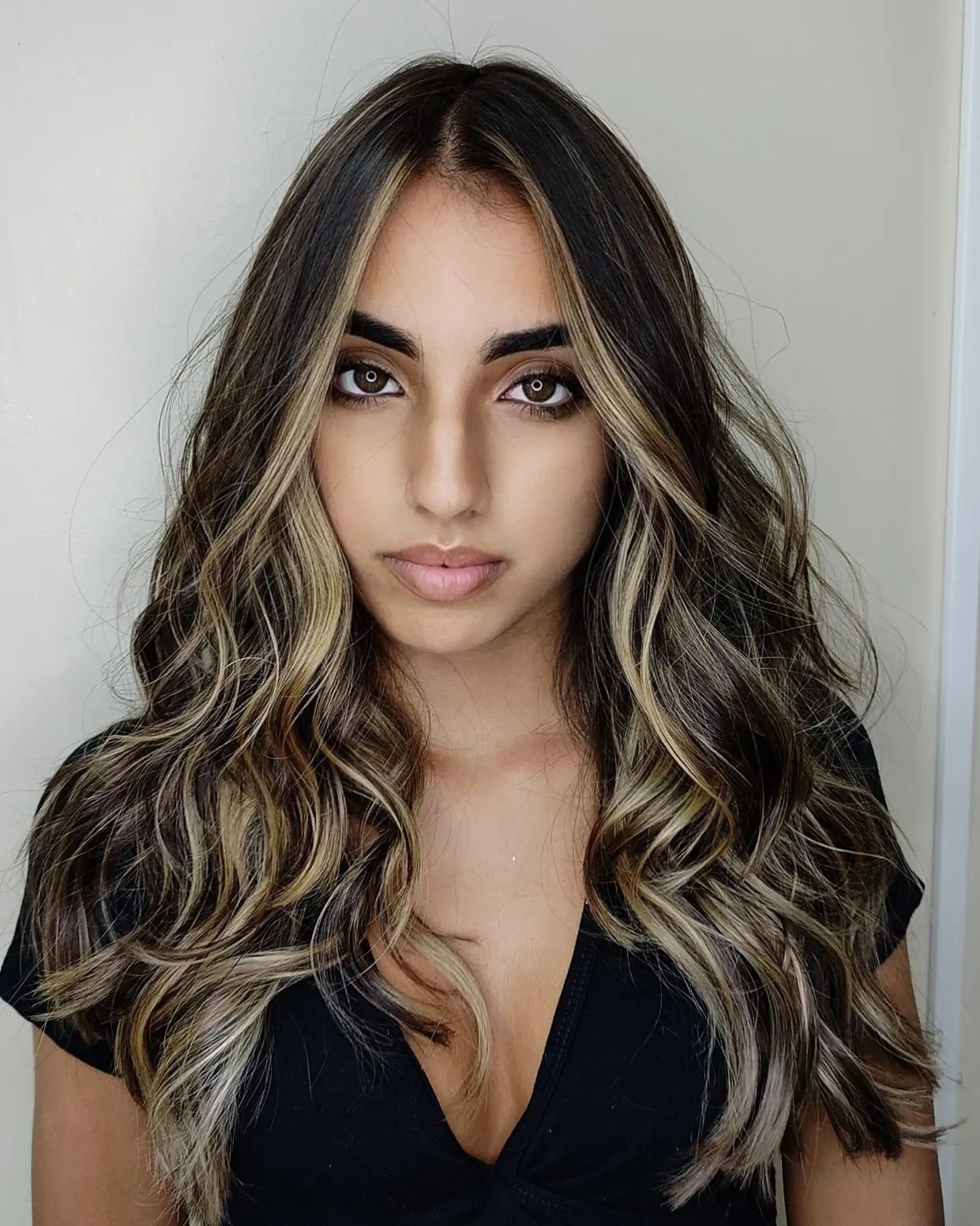 Morena iluminada natural em cabelo castanho com ondas, resultado do salão em Guarulhos