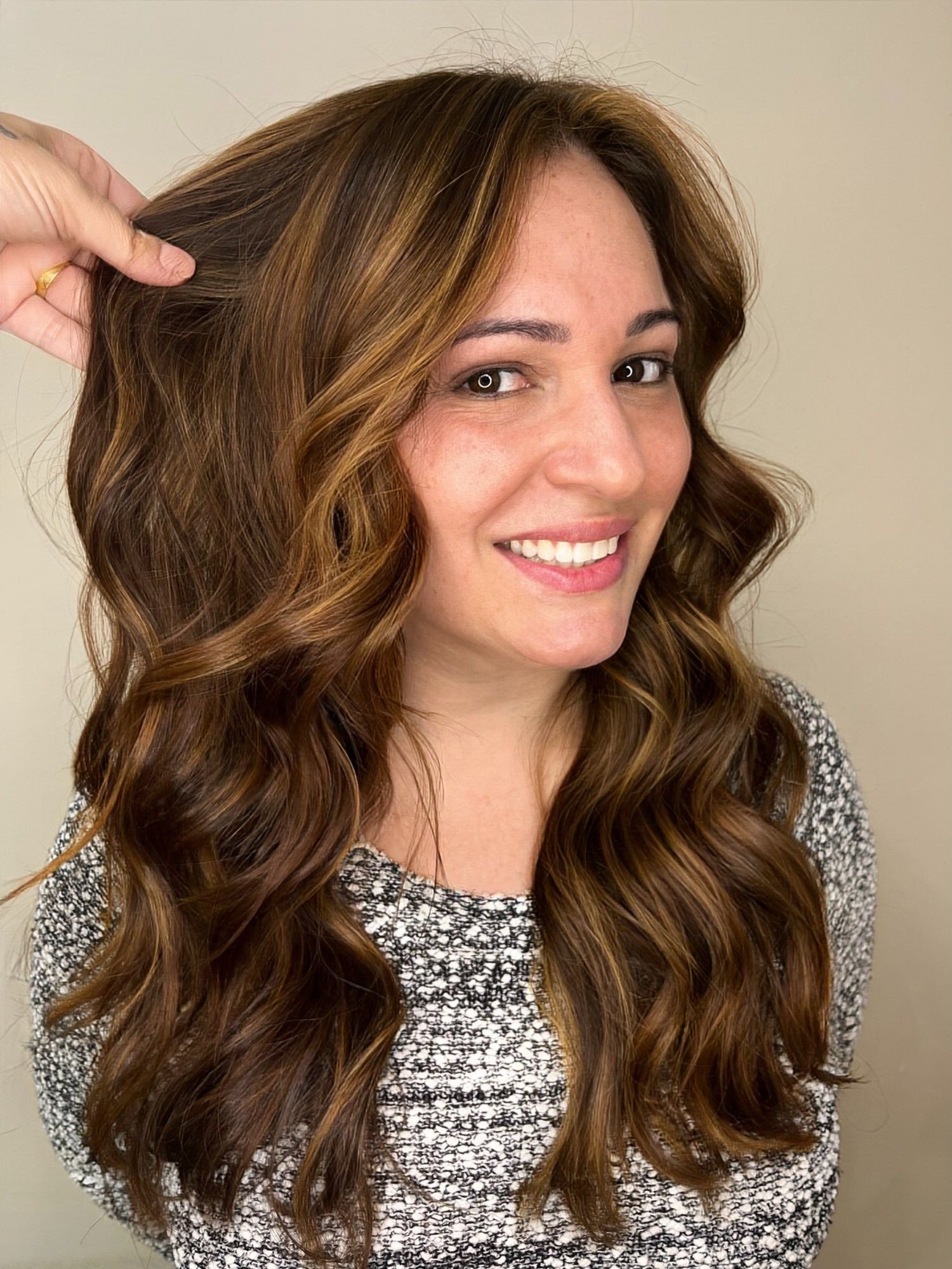 Castanho iluminado com reflexo acobreado e caramelo em cabelo longo ondulado