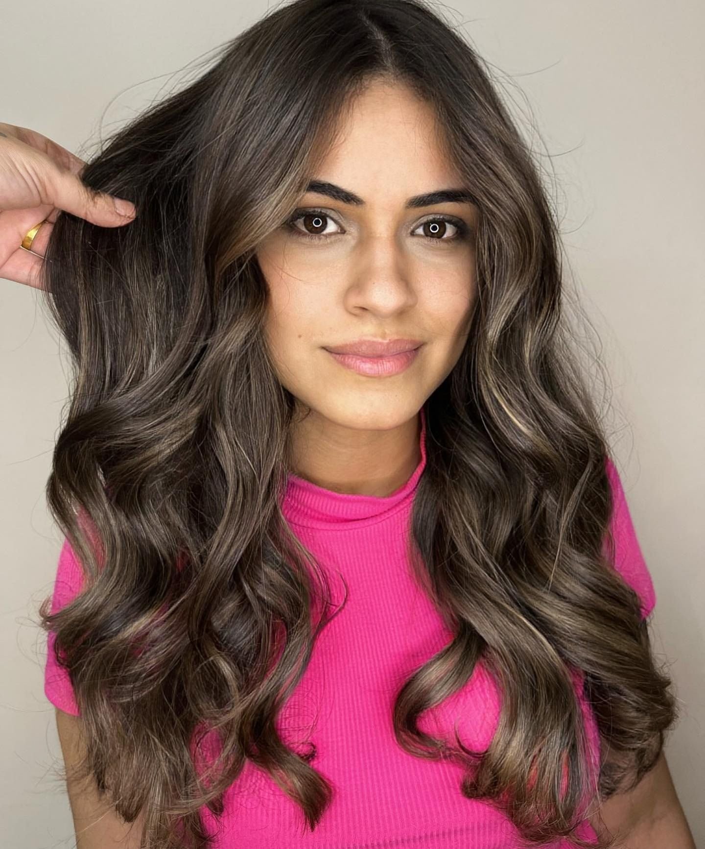 Morena iluminada chocolate com luzes suaves em cabelo longo ondulado