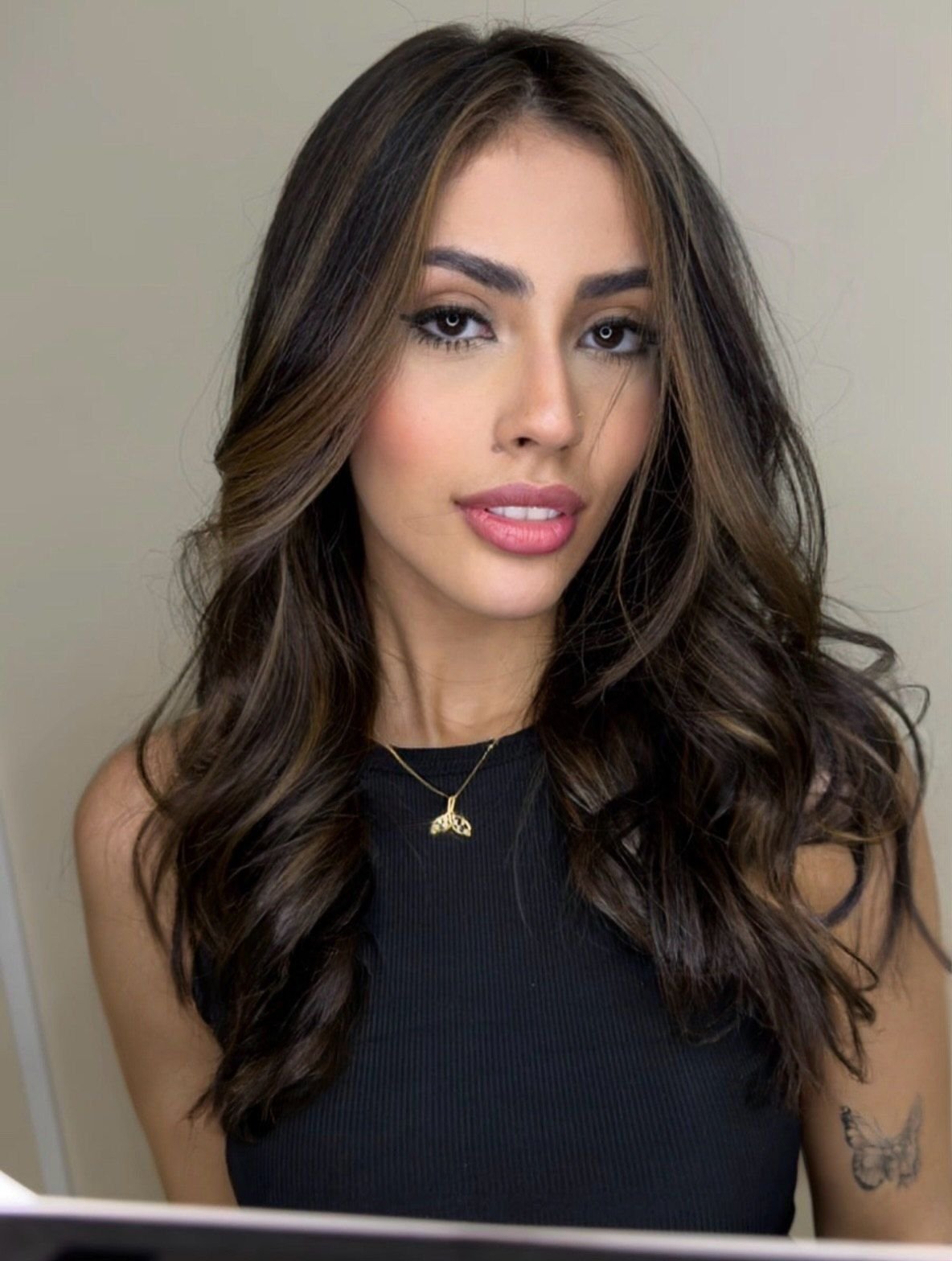 Morena iluminada sutil com luzes caramelo finas em cabelo castanho escuro longo